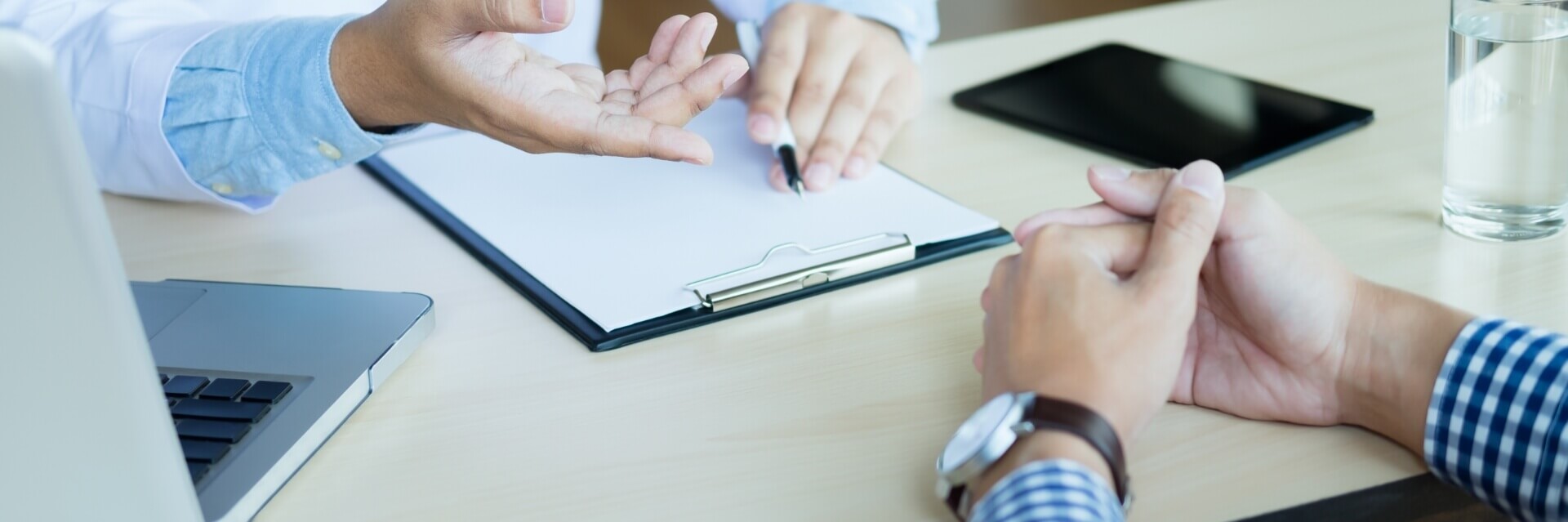 Doctor and client discussing paperwork on a clipboard