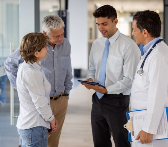 Doctor and businessman talking with a couple